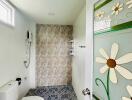 Bright bathroom with floral decor and tiled shower