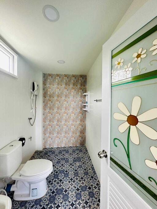 Bright bathroom with floral decor and tiled shower