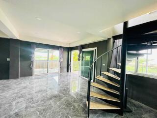 Open living area with marble floor and spiral staircase