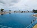 View of a large outdoor swimming pool with ocean in the background