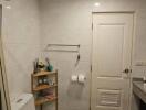 Bathroom with a white toilet, shelving, and a sink