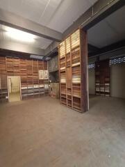 Interior view of a large warehouse with wooden shelves and partitions