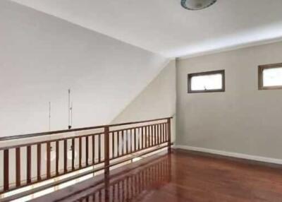 Upper level space with hardwood flooring and railing