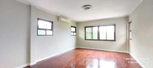 Spacious living room with hardwood floors and large windows