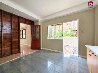 Spacious living room with wooden door and tiled floor