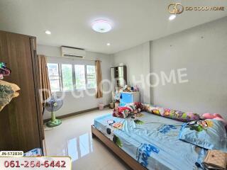 Bedroom with double bed, dresser, air conditioner, and fan
