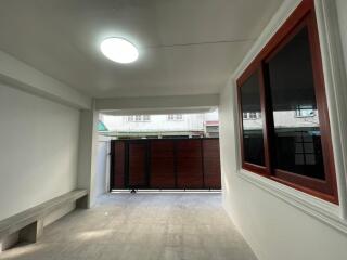 Covered outdoor space with concrete bench and large window