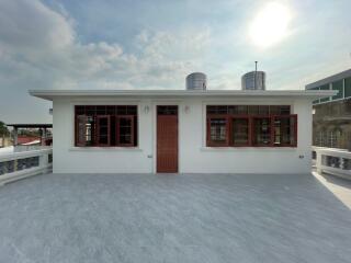 Outdoor space with white building and red door