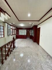 Spacious living room with marble flooring and wooden accents.