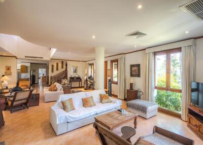 Spacious living room with large windows, seating area, and natural light