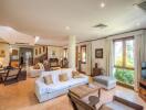 Spacious living room with large windows, seating area, and natural light