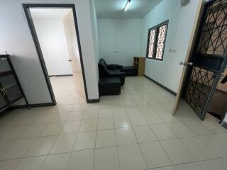 Living room with tiled floor and black sofas