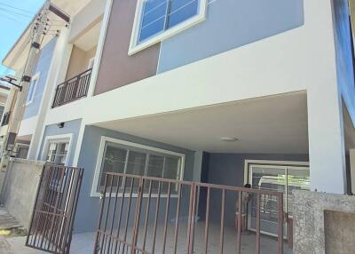 Front view of a modern two-story house with a gated driveway