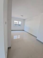 Spacious living room with large window and tiled floor