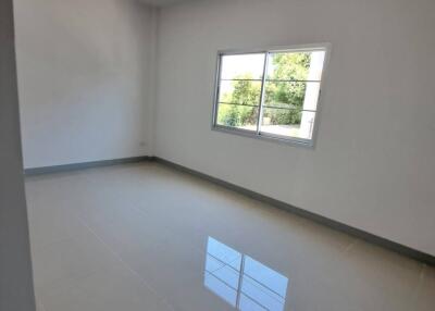 Empty bedroom with tiled floors and a window