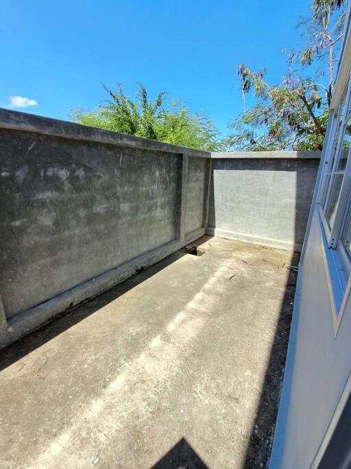 Outdoor area with concrete flooring and high walls