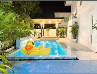 Backyard view with a swimming pool and a large rubber duck float