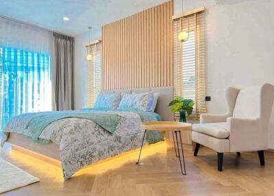 Modern bedroom with decorative wooden panel, cozy bed, and accent chair