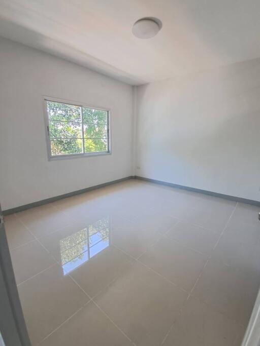 Empty bedroom with tiled floor and a window