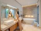 Modern bathroom with vanity, bathtub, and decorative stone wall