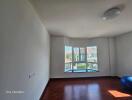 Empty room with wooden floor and large window