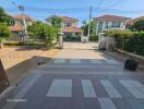 View of a residential driveway with houses in the background