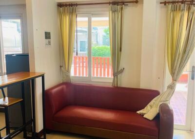 Living room with a red sofa, window, and door leading to an outdoor area