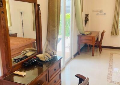 Bedroom with dressing table, desk, and large windows