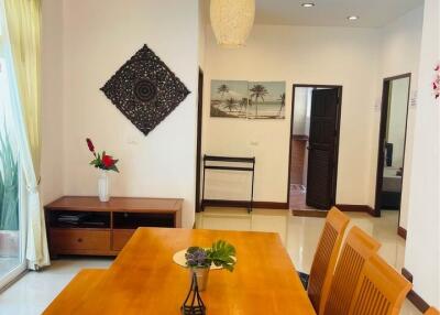 Dining area with wooden table and chairs, decorative lighting, and wall art