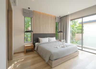 Modern bedroom with large windows and a neatly made bed