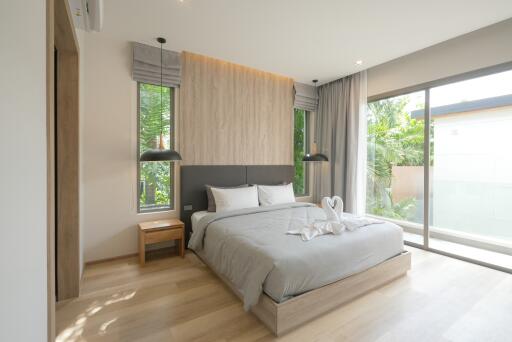 Modern bedroom with large windows and a neatly made bed