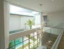 Modern two-story house with glass railing overlooking pool area