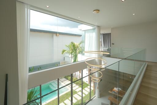 Modern two-story house with glass railing overlooking pool area