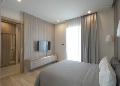 Modern bedroom with contemporary decor, window, and wall-mounted TV