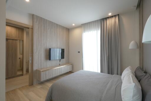Modern bedroom with contemporary decor, window, and wall-mounted TV