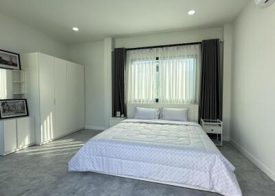 Light and airy bedroom with double bed and modern white decor.