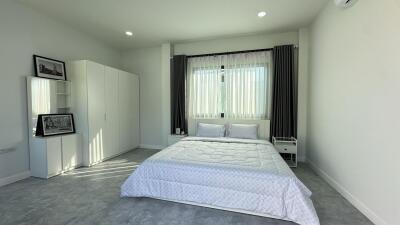 Light and airy bedroom with double bed and modern white decor.