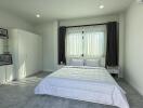 Light and airy bedroom with double bed and modern white decor.