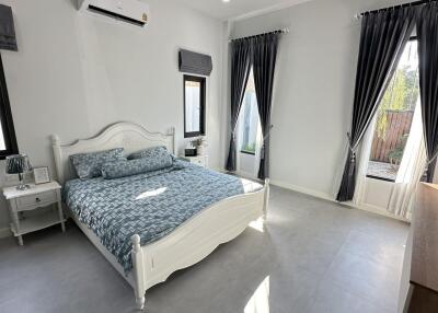 Cozy bedroom with a double bed, gray curtains, and ample natural light