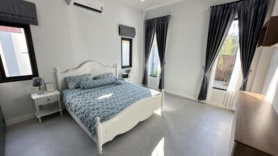 Cozy bedroom with a double bed, gray curtains, and ample natural light