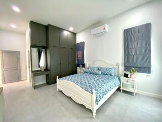 Spacious bedroom with bed, wardrobe, and air conditioner