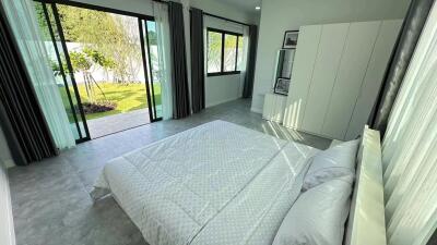 Bright and spacious bedroom with large windows and garden access