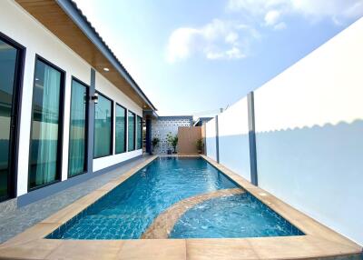 Outdoor swimming pool beside building with clear blue sky