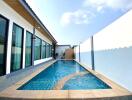 Outdoor swimming pool beside building with clear blue sky