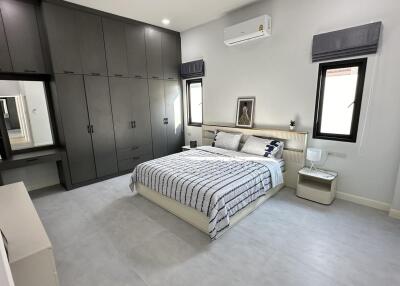 Spacious bedroom with modern decor, large built-in wardrobe, bed and nightstand