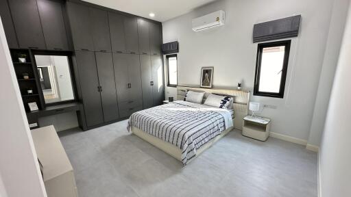 Spacious bedroom with modern decor, large built-in wardrobe, bed and nightstand