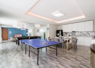 Spacious living area with table tennis, dining table, and kitchen