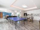 Spacious living area with table tennis, dining table, and kitchen