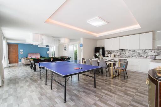 Spacious living area with table tennis, dining table, and kitchen