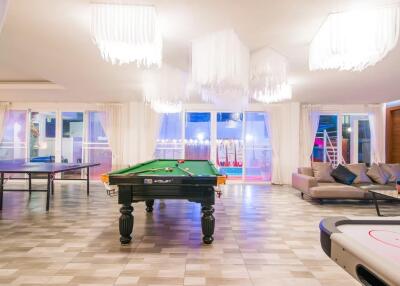 Spacious entertainment room with pool table, ping pong table, and seating area